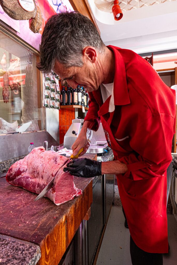 Macellaio che taglia la carne fresca