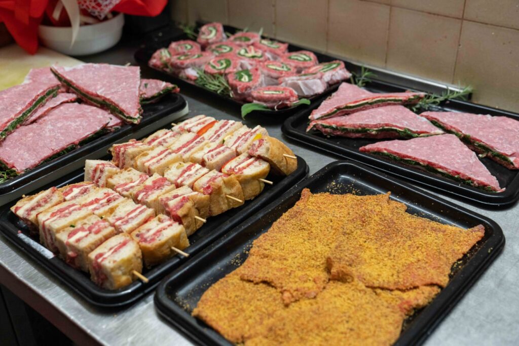 Vassoi di preparazioni pronte a cuocere della Macelleria Bianchi: spiedini, involtini, rotoli ripieni e cotolette impanate